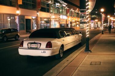 white limousine on a dark city street. you can drink alcohol in a limo in alberta as long as you are licensed.