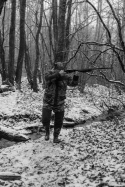 man walking while aiming a rifle. You can hunt in alberta without a pal, but you must be supervised by someone with a pal.