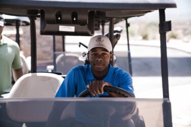 man sitting on golf cart. You can not legally drive a golf cart on roads and highways in alberta, canada.