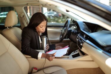 woman reading documents while in her car. You can get an alberta drivers abstract from bc or anywhere else outside the province.