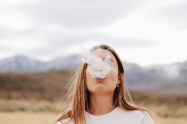 woman smoking cigarette. Menthol cigarettes are banned in Alberta and the rest of Canada.