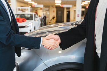 Car dealership hand shake. You must be a licensed seller to sell a vehicle in Alberta.