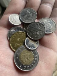 Canadian coins in palm of hand. There are legal limits on how many coins you can use in Canada.