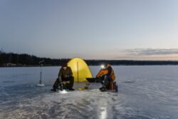 people ice fishing at night with a tent. You can legally ice fish on beaver ponds and tributaries in Alberta, but only in certain places.