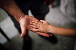 father and child’s hands together. We explore the topic of “when can a child refuse visitation rights in alberta?”.