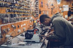 young man at a workbench doing a job. You can work while on aish in alberta, canada, but there are clawbacks after an exempt amount of income.
