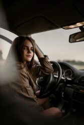 young woman sitting inside car. You no longer need to take the advanced driver test to exit GDL program in Alberta canada.