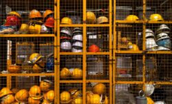 a rack filled with lots of yellow hard hats. What is the Alberta OHS?